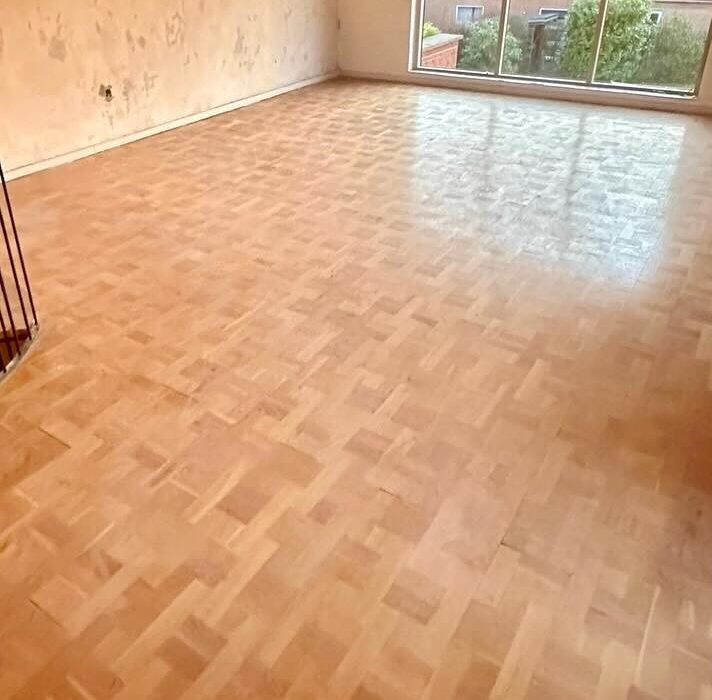 Lyst rum med parketgulv og stor vinduesparti